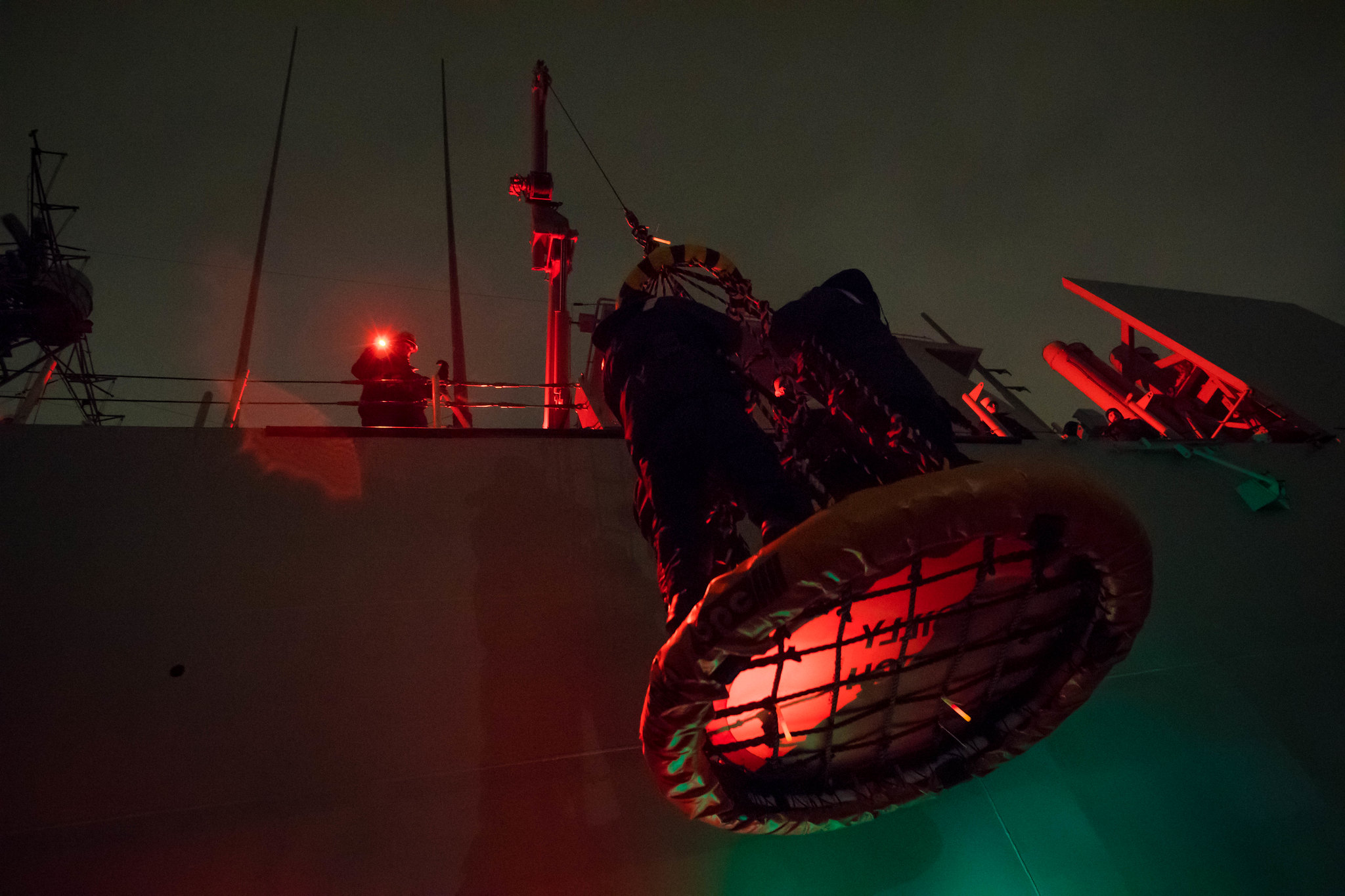 Sailors are hoisted aboard a ship